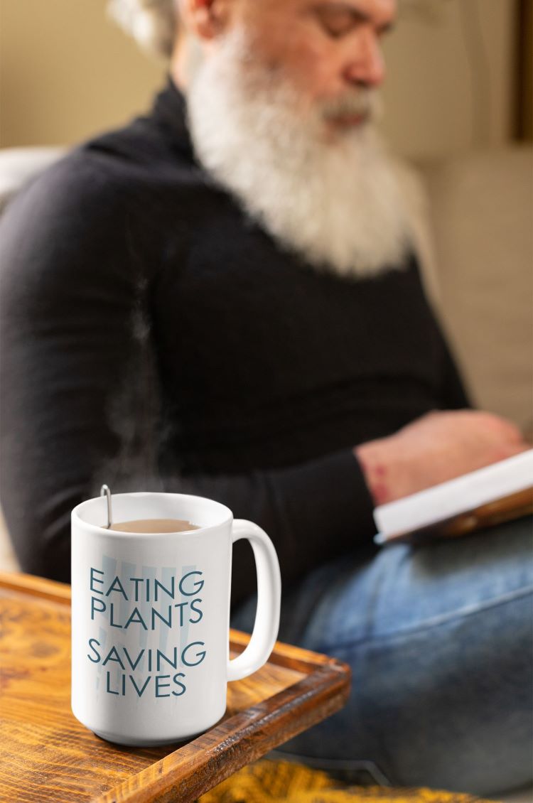 Glossy mug with "Eating Plants, Saving Lives" slogan for plant-based advocacy