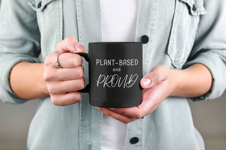 Glossy mug with 'Plant-Based and Proud' slogan promoting a meat-free lifestyle