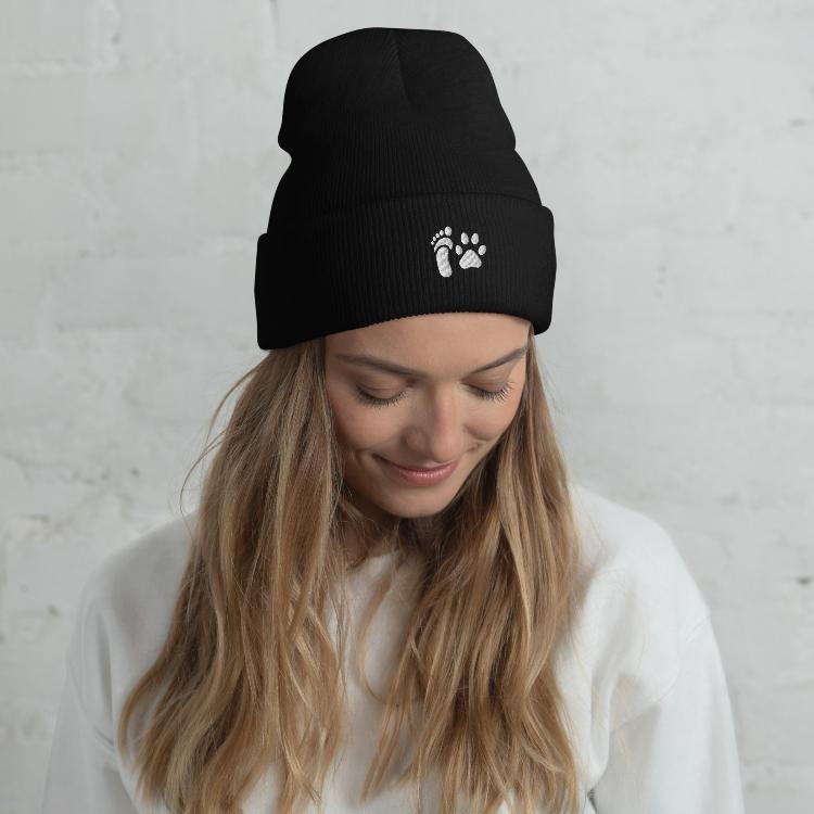 Cuffed beanie with human foot and animal paw embroidery symbolizing unity