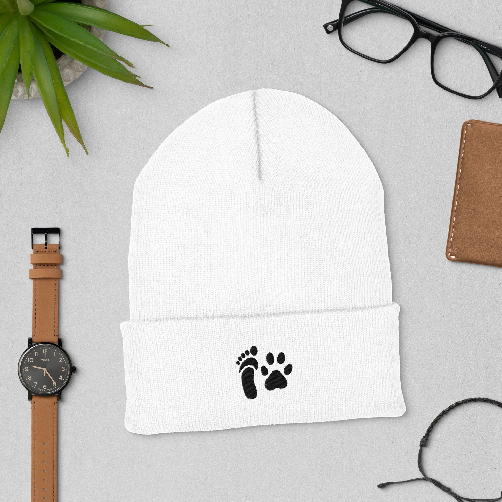 Cuffed beanie featuring human foot and animal paw embroidery for unity