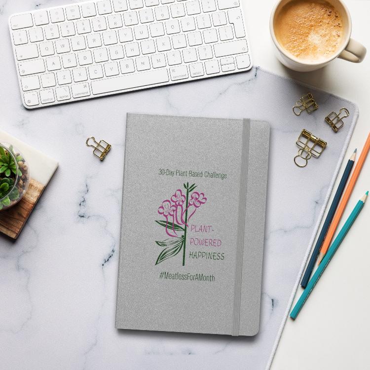 Vegetizer Hardcover Notebook with 'Plant-Powered Happiness' message, 80 lined cream-colored pages, elastic closure, ribbon marker, expandable inner pocket, eco-friendly design, promoting plant-based lifestyle