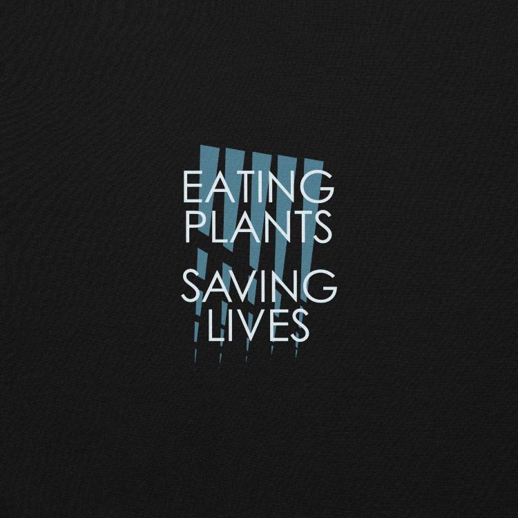 Cozy plant-based sweatshirt with the slogan 'Eating Plants, Saving Lives' on the front, featuring a label with human foot and animal paw prints, promoting animal welfare and a meat-free lifestyle