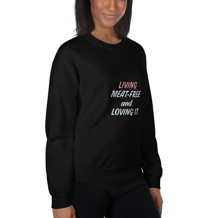 Sweatshirt featuring the slogan 'Living Meat-Free and Loving It', with human foot and animal paw prints on the label. Promotes a plant-based lifestyle and awareness for animal welfare