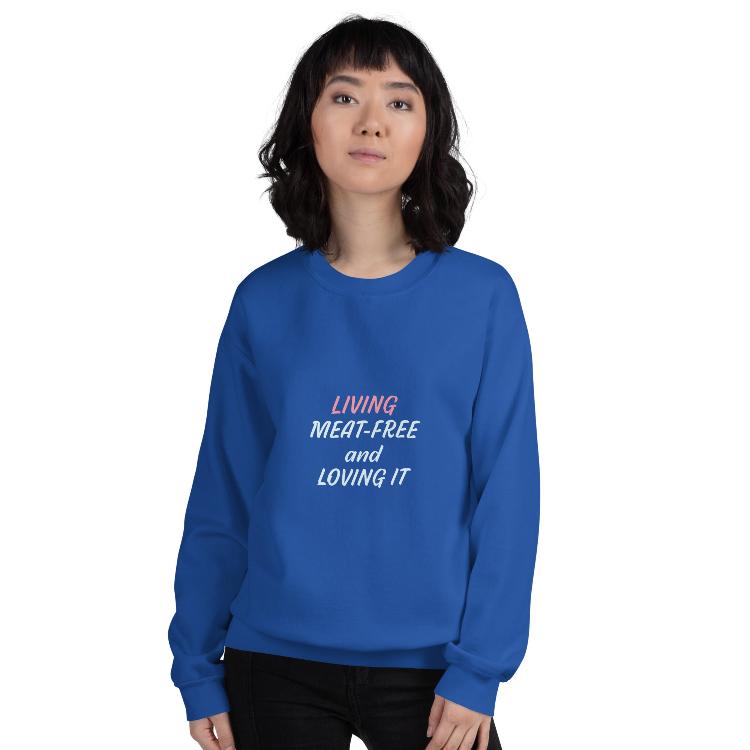 Sweatshirt featuring the slogan 'Living Meat-Free and Loving It', with human foot and animal paw prints on the label. Promotes a plant-based lifestyle and awareness for animal welfare