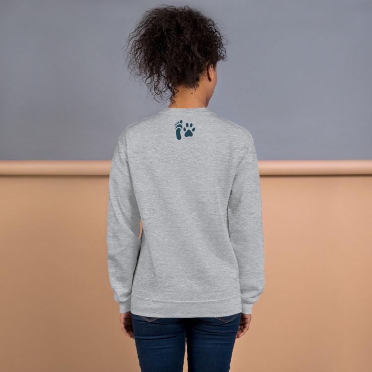 Cozy sweatshirt featuring the slogan "Plant-Based and Proud" on the front, with a human foot and animal paw print on the outside label, symbolizing harmony between humans and animals. Made from a blend of 50% cotton and 50% polyester, this pre-shrunk classic fit sweatshirt is ideal for colder months, promoting a plant-based lifestyle and raising awareness for animal welfare