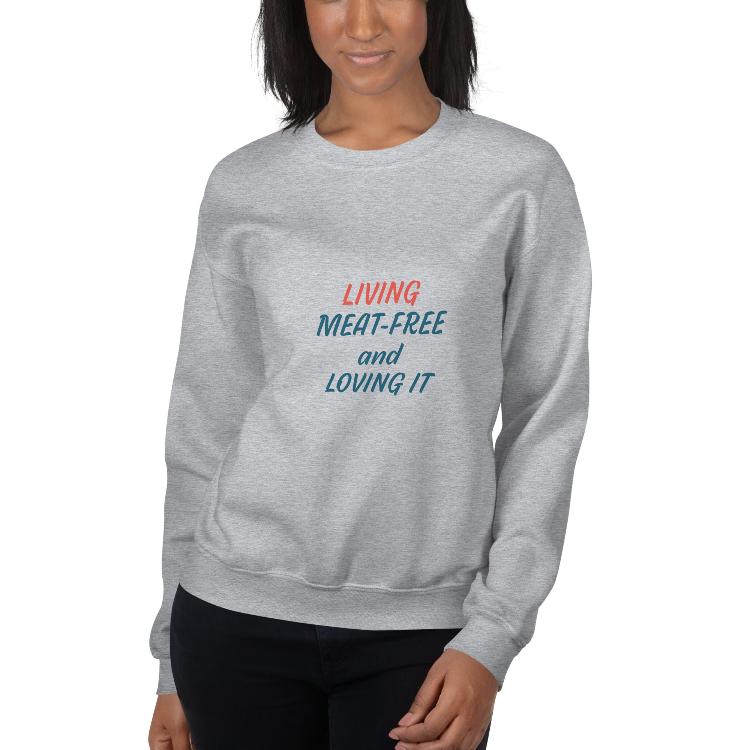 Comfortable plant-based sweatshirt with the slogan 'Living Meat-Free and Loving It'. Features human foot and animal paw prints symbolizing harmony. Ideal for promoting a plant-based lifestyle and animal welfare awareness