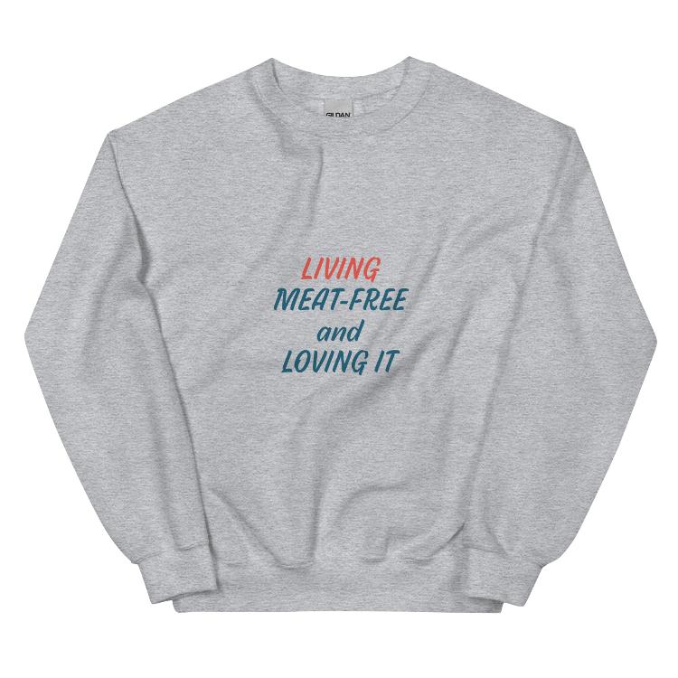 Comfortable plant-based sweatshirt with the slogan 'Living Meat-Free and Loving It'. Features human foot and animal paw prints symbolizing harmony. Ideal for promoting a plant-based lifestyle and animal welfare awareness