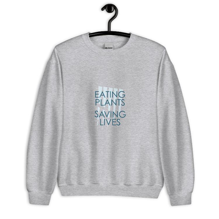 Cozy plant-based sweatshirt featuring the slogan 'Eating Plants, Saving Lives' on the front, with human foot and animal paw prints on the label, promoting the 30-Day Plant-Based Challenge and raising awareness for animal welfare