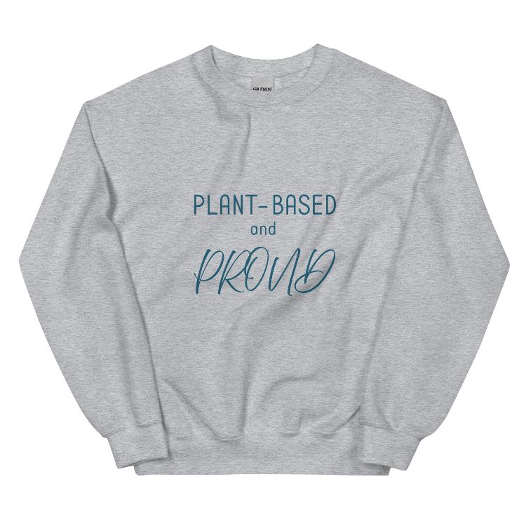 Cozy sweatshirt featuring the slogan "Plant-Based and Proud" on the front, with a human foot and animal paw print on the outside label, symbolizing harmony between humans and animals. Made from a blend of 50% cotton and 50% polyester, this pre-shrunk classic fit sweatshirt is ideal for colder months, promoting a plant-based lifestyle and raising awareness for animal welfare