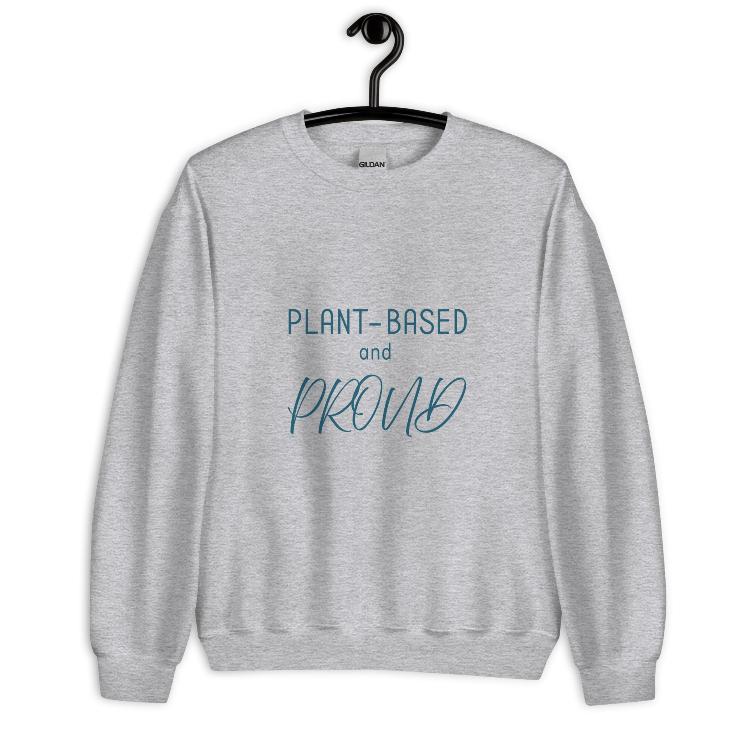 Cozy sweatshirt featuring the slogan "Plant-Based and Proud" on the front, with a human foot and animal paw print on the outside label, symbolizing harmony between humans and animals. Made from a blend of 50% cotton and 50% polyester, this pre-shrunk classic fit sweatshirt is ideal for colder months, promoting a plant-based lifestyle and raising awareness for animal welfare