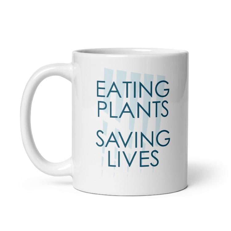 Glossy mug with "Eating Plants, Saving Lives" slogan for plant-based advocacy